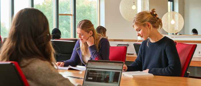 Two students at a desk filling in their applications